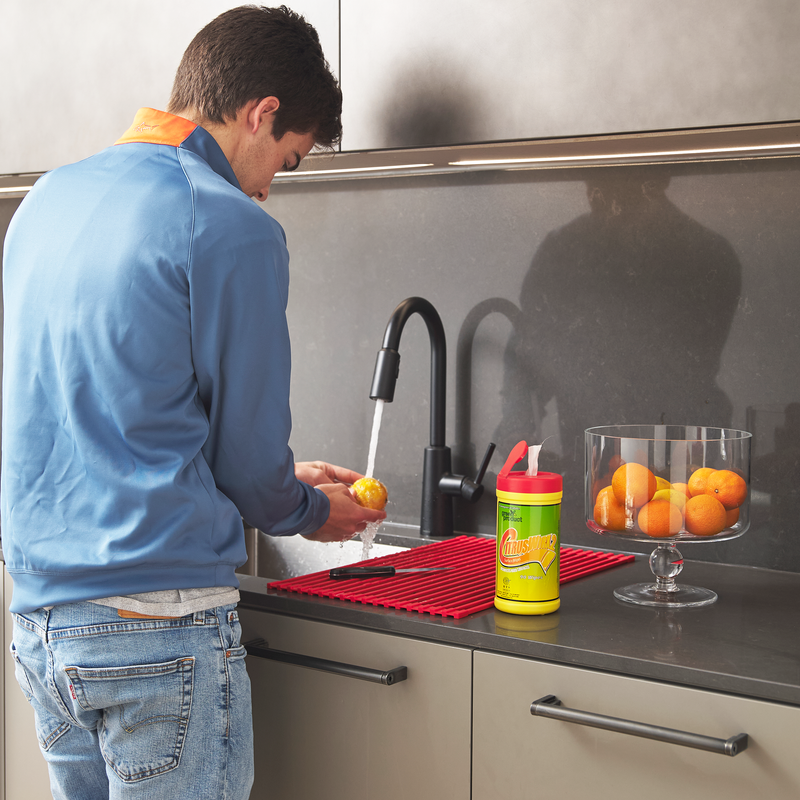 Man preparing food in residential kitchen next to citruswirx wipes cannister