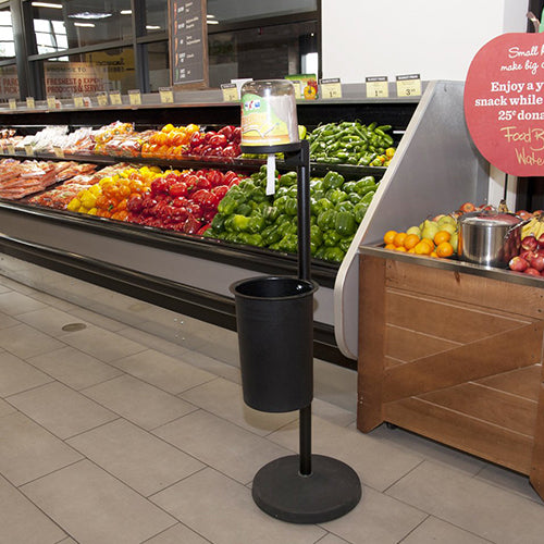CitrusWirx disinfectant wipe dispenser on black stand in grocery store produce section